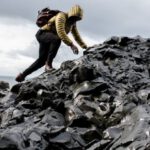 Challenges - Man Wearing Hoodie and Black Pants Climbing Up Pile of Rocks