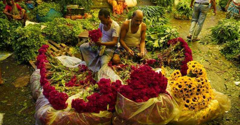 Market Disruptions - Men Preparing Bouquets on Marker