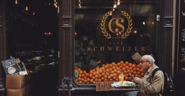 Consumer Behavior - Man in Brown Jacket Sitting on Chair in Front of Fruit Stand