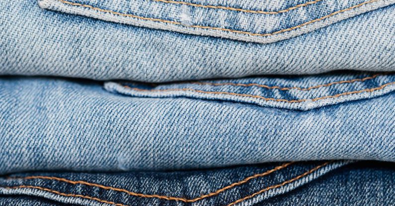 Market Trends - Stack of blue jeans arranged by color