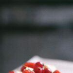 Traits - A small dessert with strawberries and cream on a plate