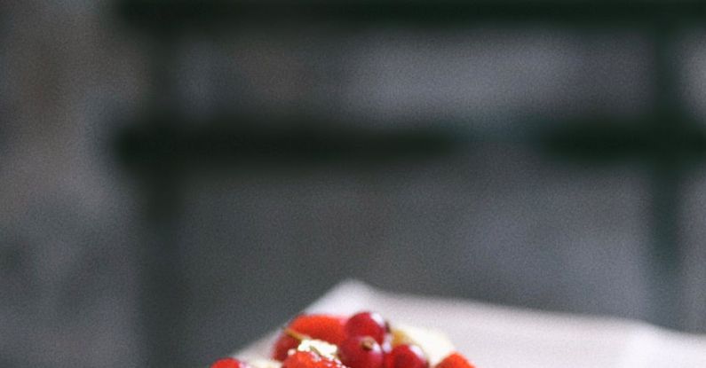 Traits - A small dessert with strawberries and cream on a plate
