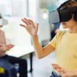 Wearable Technologies - Young female in VR glasses standing in light room and testing new device