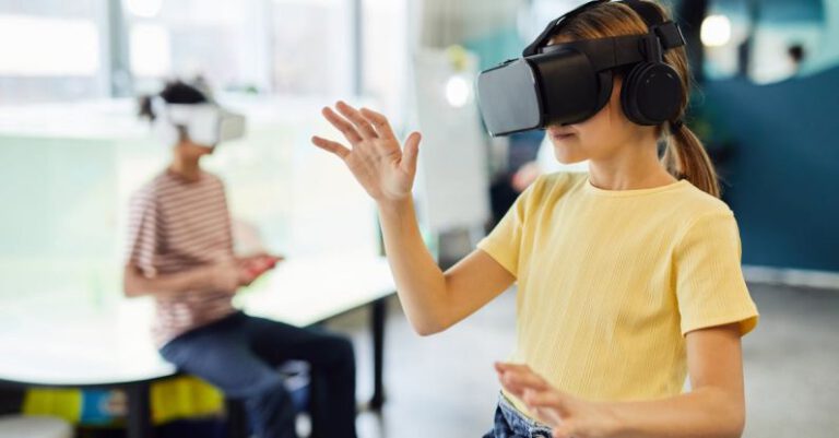 Wearable Technologies - Young female in VR glasses standing in light room and testing new device